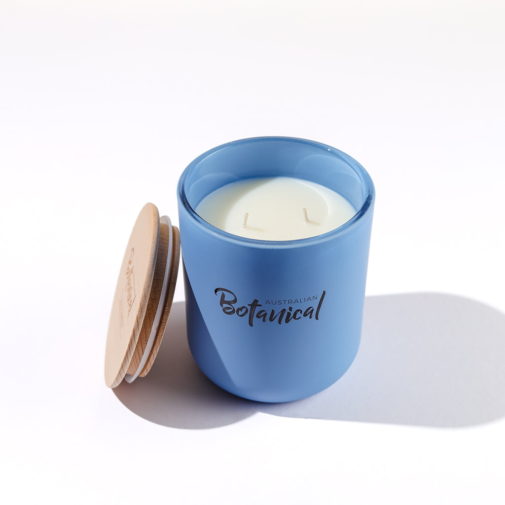 Blue candle jar with a wooden lid on a white background