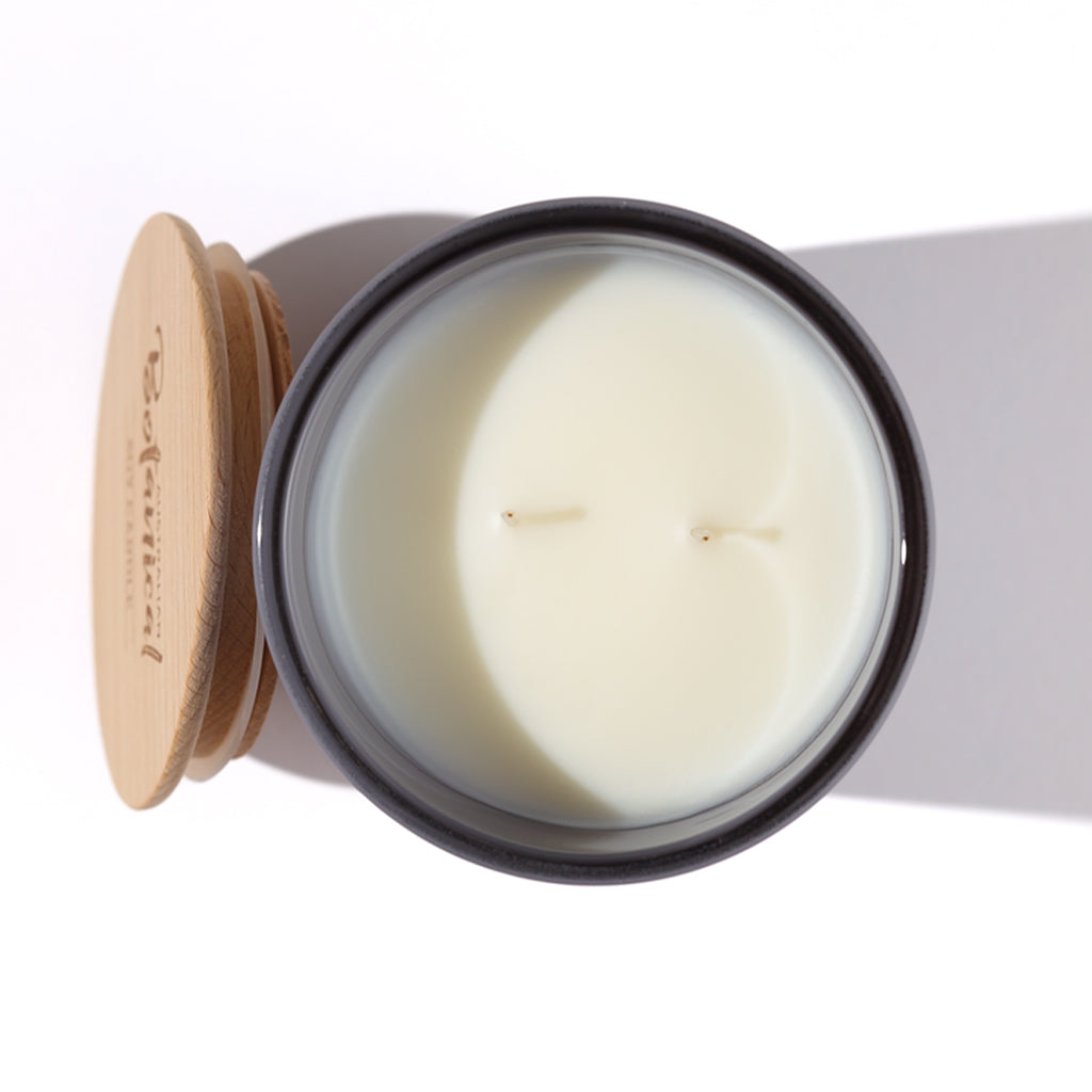Candle in a glass jar with a wooden lid on a white background