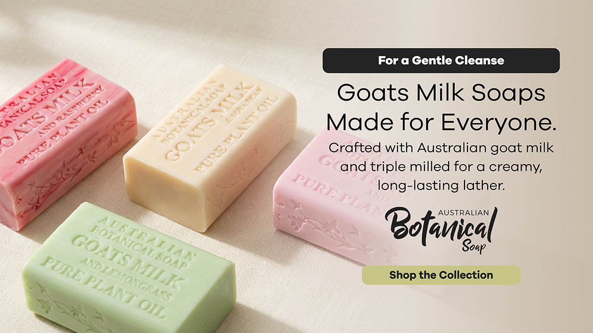 Four bars of goats milk soap in pink, green, and beige on a light background with promotional text.