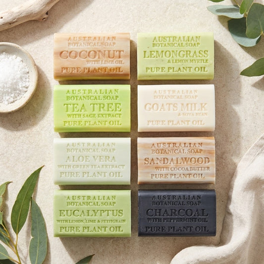 Various types of Australian Botanical Soap bars on a textured surface with leaves.