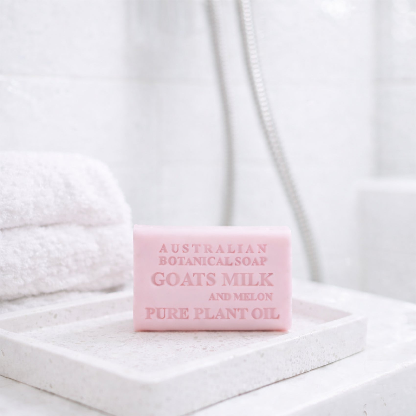Goats Milk and Melon bar of soap with 'Australian Botanicals' branding on a white towel background