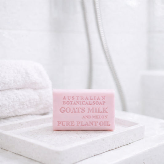 Goats Milk and Melon bar of soap with 'Australian Botanicals' branding on a white towel background