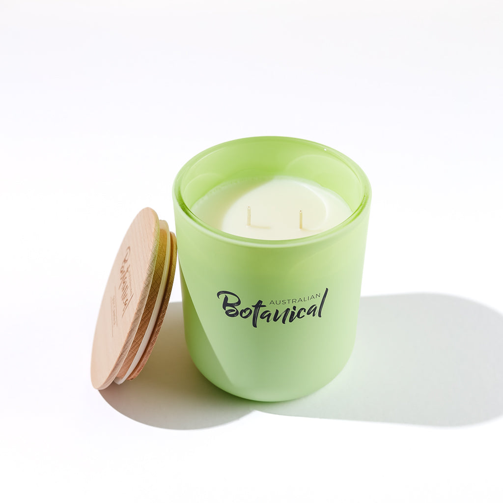 Green candle with wooden lid on a white background