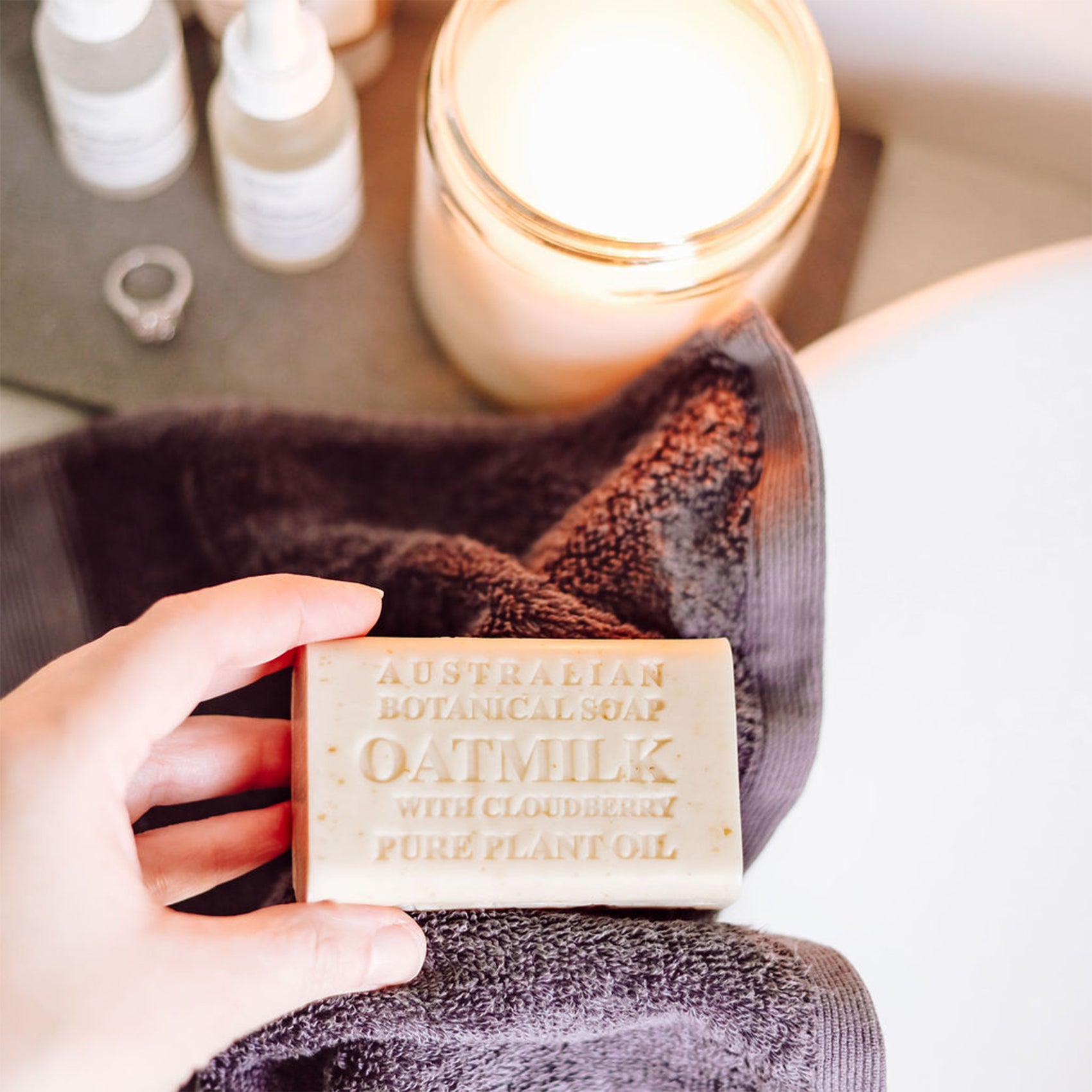 Person holding a bar of soap over a sink