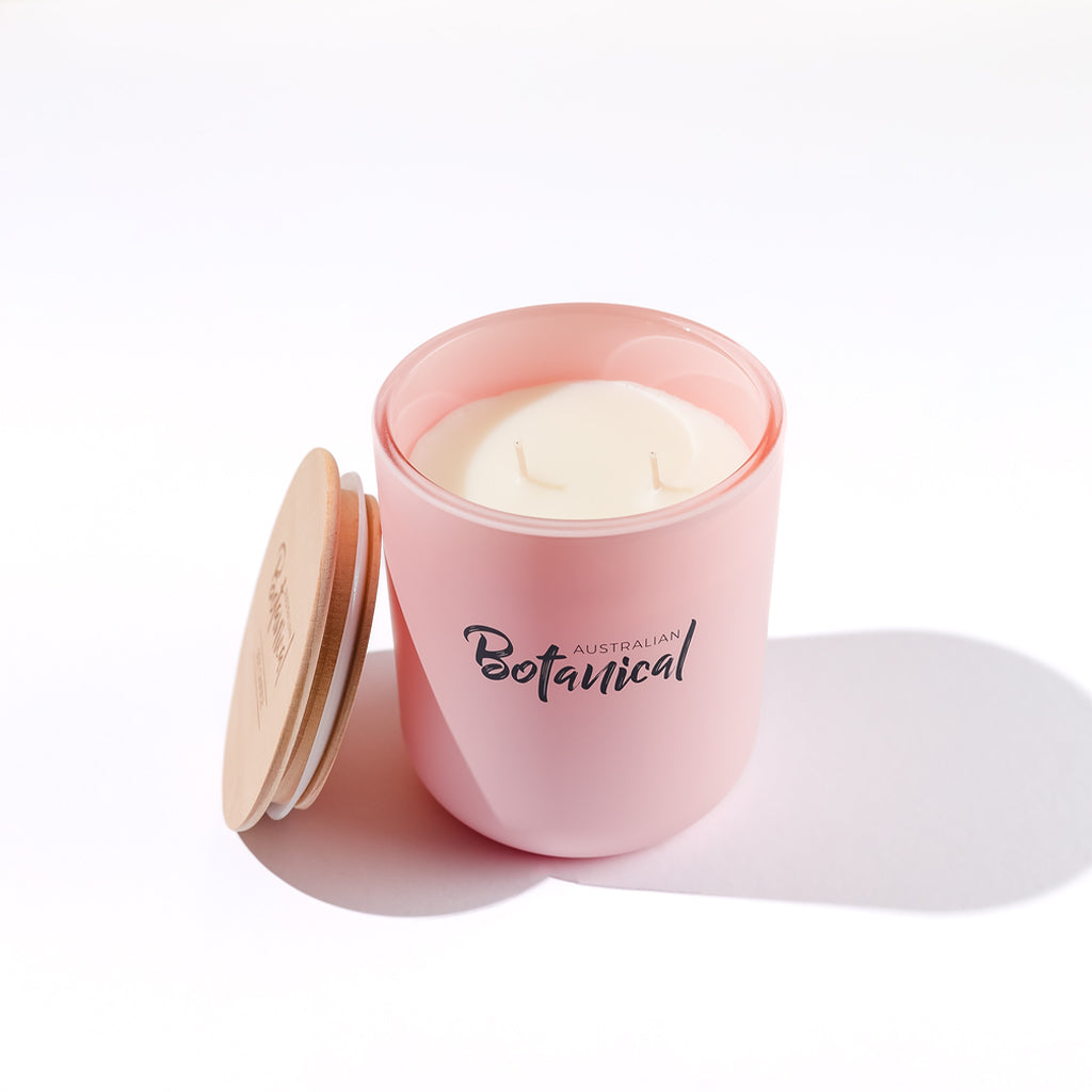 Pink candle with 'Australian Botanical' branding on a white background