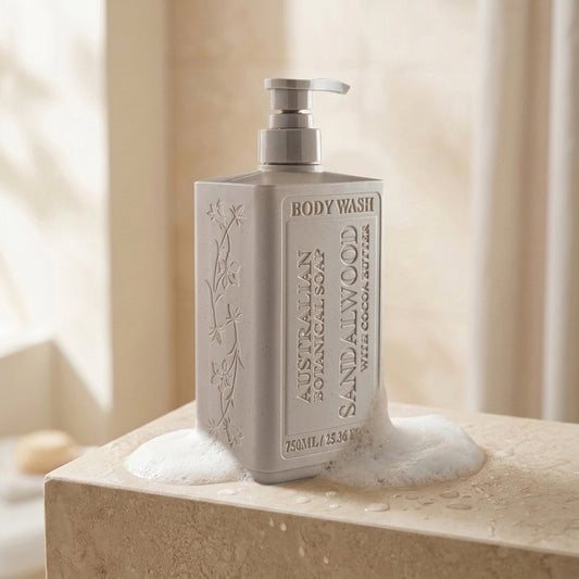 Sandalwood with Cocoa Butter body wash bottle on counter with creamy lather around it