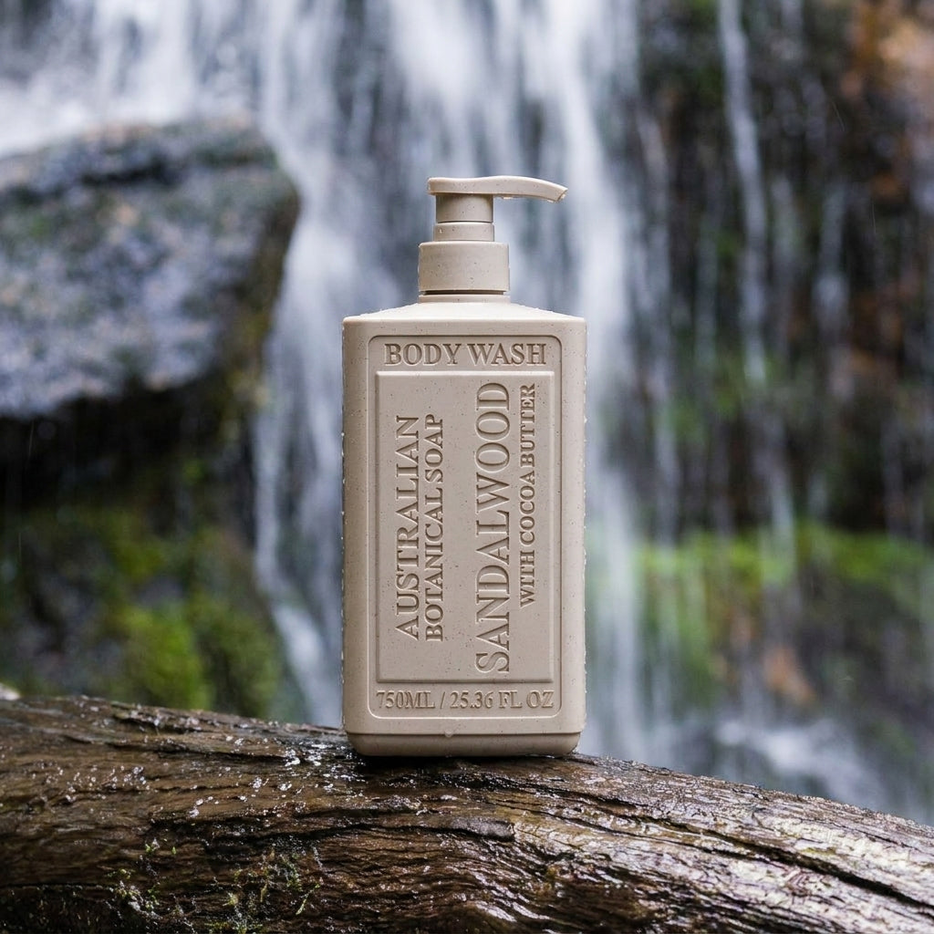 Sandalwood body wash bottle on a log in front of an Australian waterfall