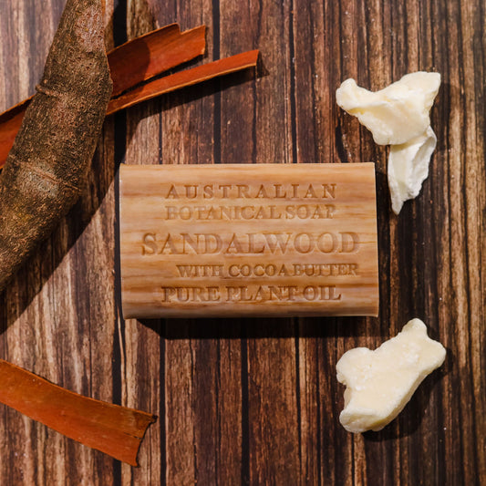 Sandalwood soap bar on a wooden background with cocoa butter and pieces of sandalwood