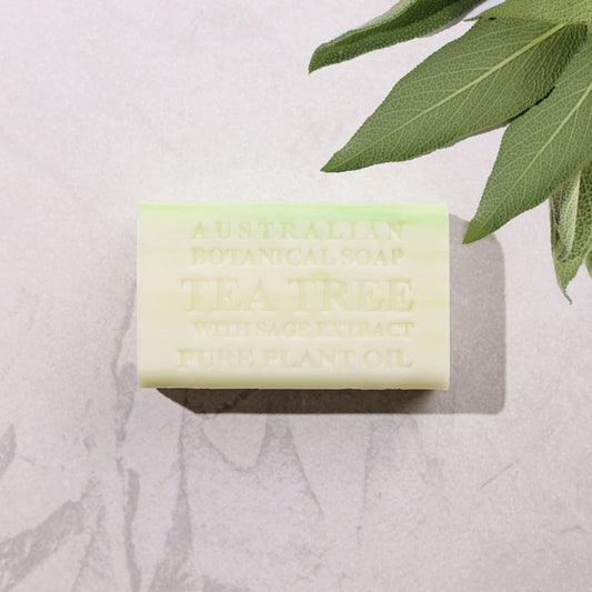 Bar of soap with 'Tea Tree' text on a light background with green leaves.