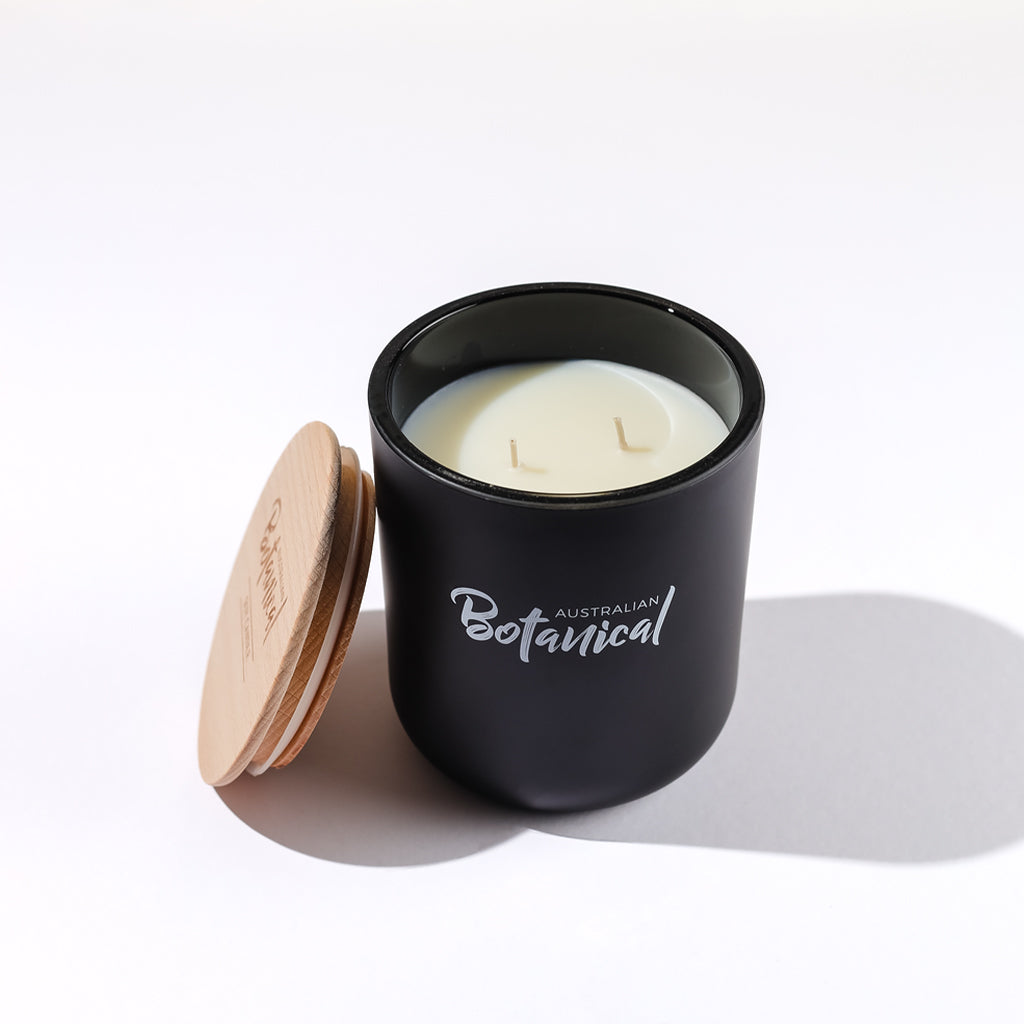 Black candle jar with wooden lid on a white background, featuring 'Australian Botanical' branding.
