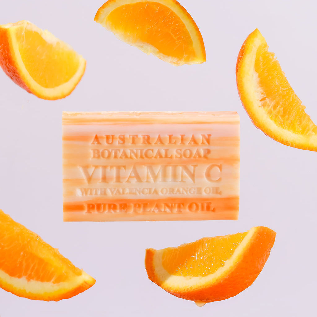 Bar of Australian Botanical Soap with Vitamin C surrounded by orange slices on a light purple background