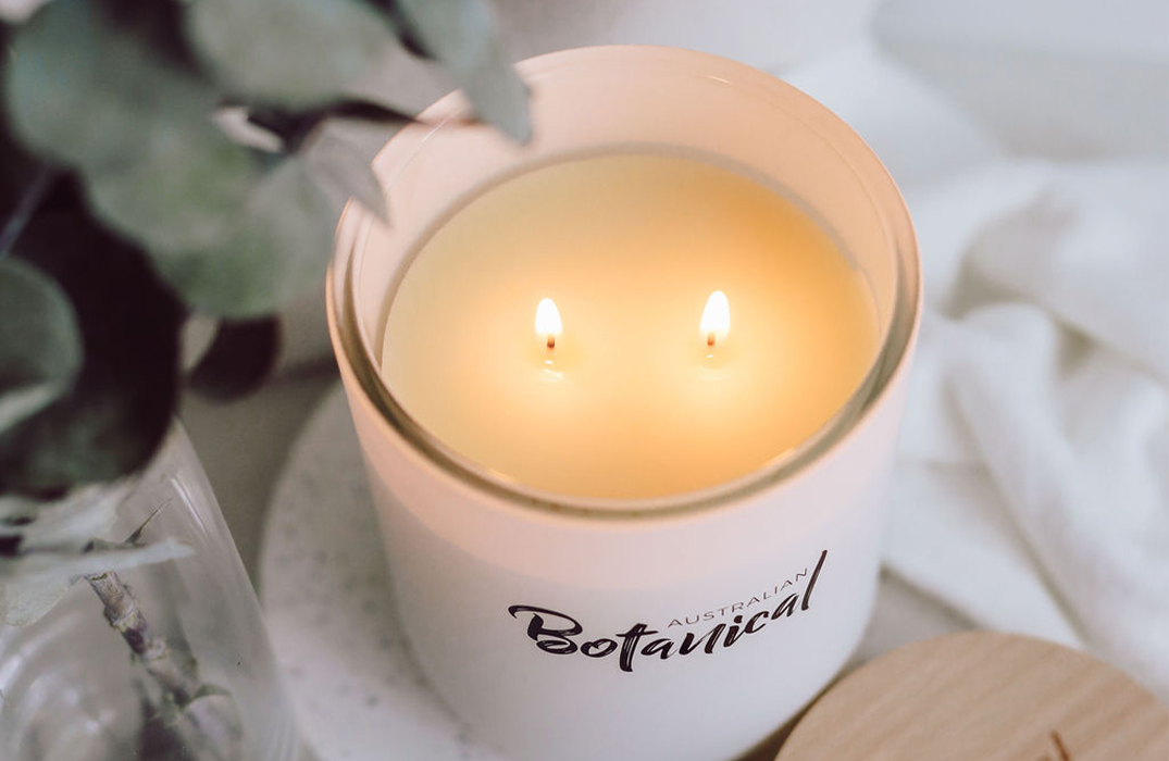 Vanilla Caramel Soy Candle on table with twin wicks lit